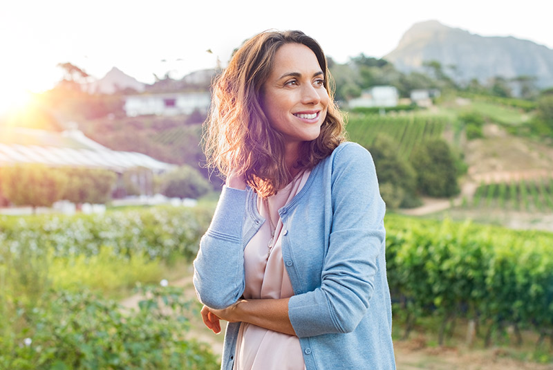 Very nice lady smiling looking off to the side while sun sets in the background