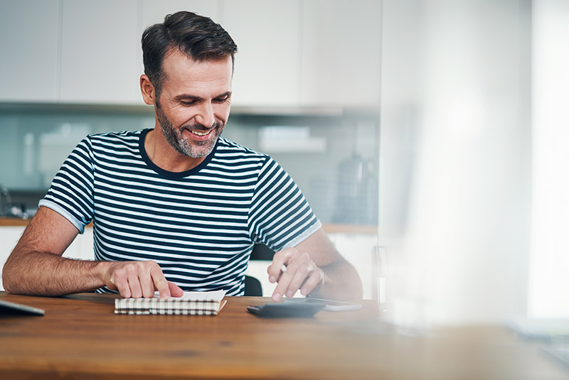 Very nice guy at home smiling doing finances