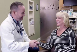 Jonny Shanks, DDS speaking and shaking patients hand while they smile at each other