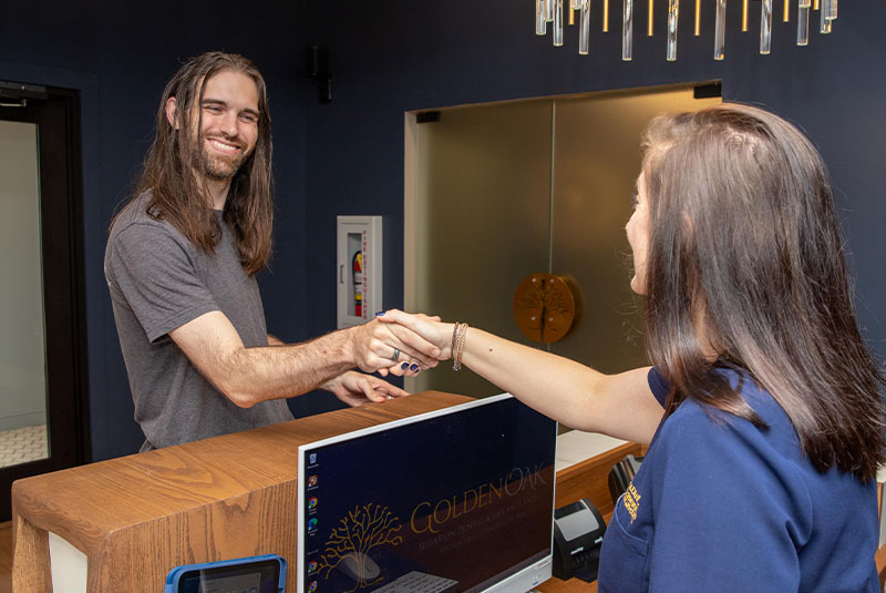 Dental patient shaking hands with receptionist