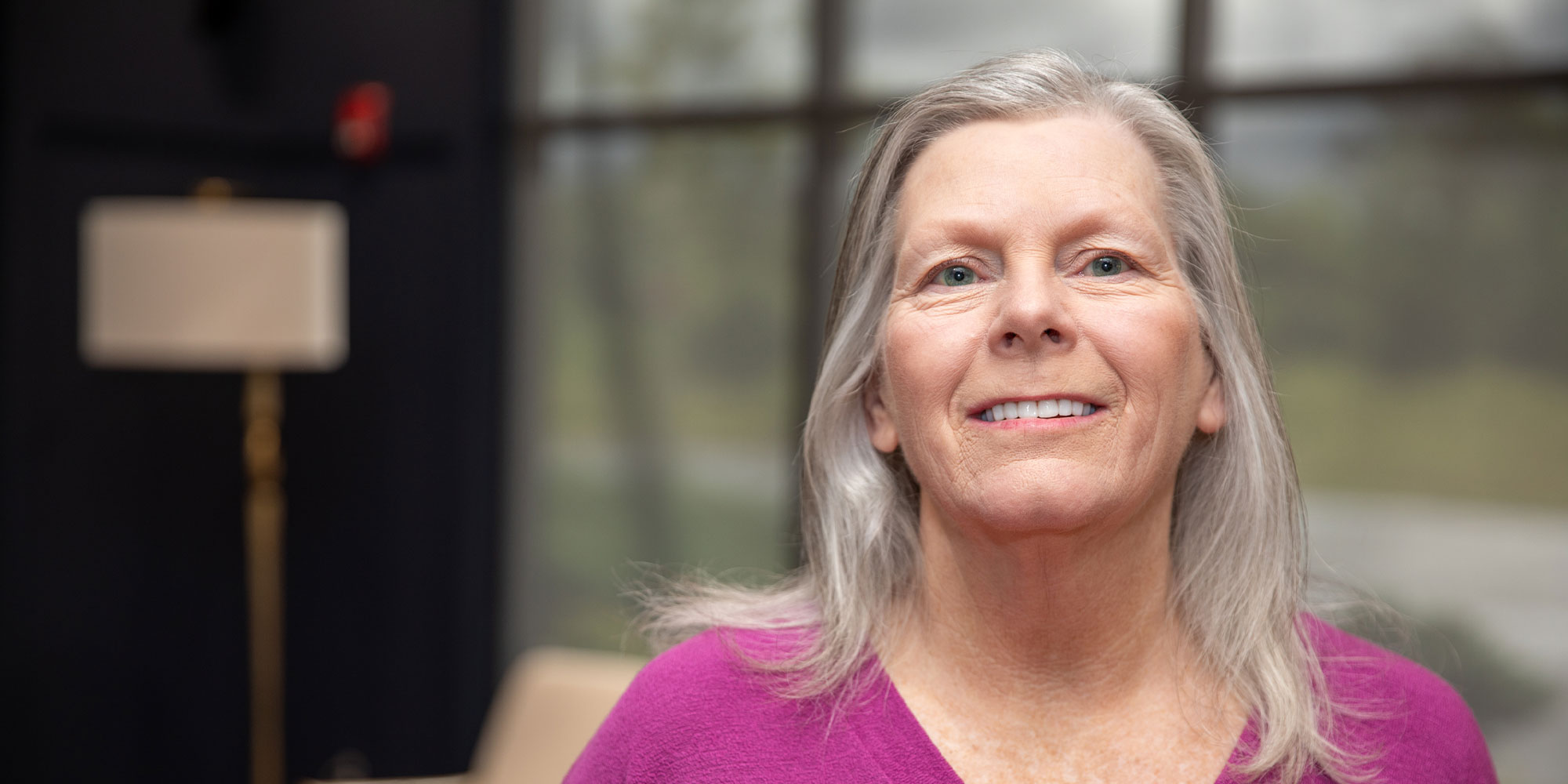 headshot of patient smiling brightly after their dental treatment