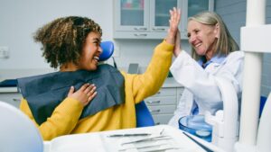 women smiling and talking with a dentist
